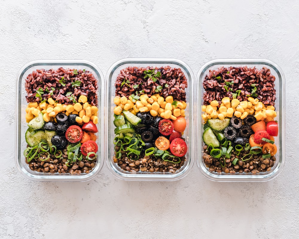 Person preparing healthy meals with fresh vegetables and whole grains